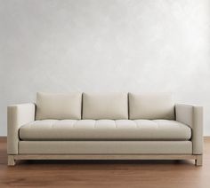 a white couch sitting on top of a hard wood floor