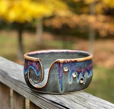 a ceramic bowl sitting on top of a wooden fence