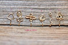 four different types of metal hooks on a wooden surface with text that reads, gold or silver