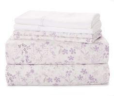 three sheets stacked on top of each other with purple flowers all over the sheet set