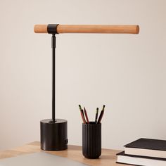 a desk with a pen holder and pencils on it