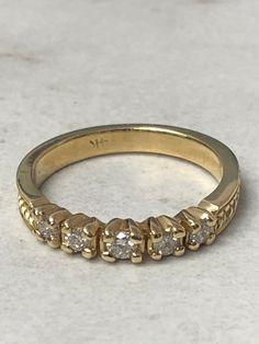 a yellow gold ring with five diamonds on it