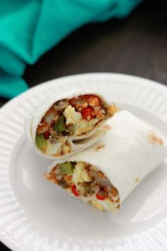 two burritos sitting on top of a white plate