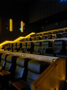 an empty theater with black leather seats and yellow neon lights on the sidelines,