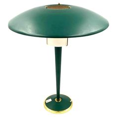 a green table lamp with a gold base