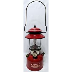 an old fashioned red lantern with a light on top