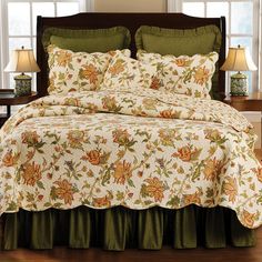 a bed with a floral comforter and matching pillows