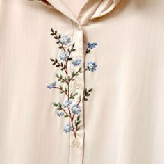 a white shirt with blue flowers on it