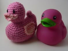 two crocheted rubber ducks sitting next to each other