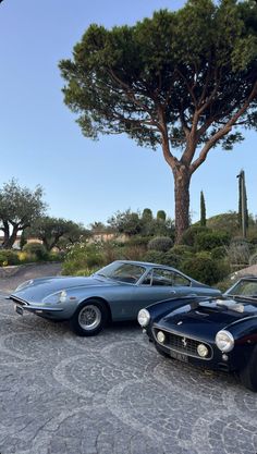 two classic sports cars parked next to each other