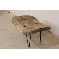 a stone bench with hairpin legs on the floor