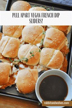 a tray full of french dip sliders with dipping sauce