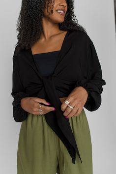 Our most versatile top. Practical and comfortable as we like. It can be tied in many ways, worn alone or layered. We love it to travel, to go out or just to feel beautiful.Made of a soft and non-stretch twill (100% viscose) fabric. It has elastics at the bottom of the sleeves to create a balloon sleeves effect. There are 2 points at the front that allow to tie it. Made in Quebec, Canada. For the modern & smart woman. Cut & size- Loose fit- Long & puffy sleeves- Hip length- Perfect match with our