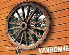 an old wagon wheel mounted to the side of a wooden building with words wwdm 48 on it