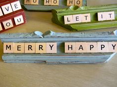 scrabbled letters spelling merry and happy on wooden blocks