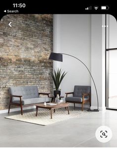 a living room with two chairs and a coffee table in front of a brick wall