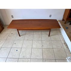 a wooden table sitting on top of a tiled floor