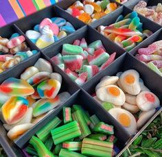 there are many different types of candies in the trays on the table together