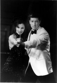 a man in a tuxedo and a woman in a sequined dress