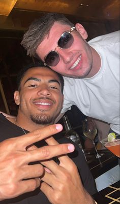 two men are posing for the camera at a restaurant