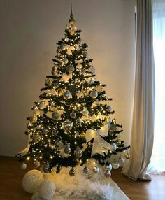 a decorated christmas tree with white and silver ornaments