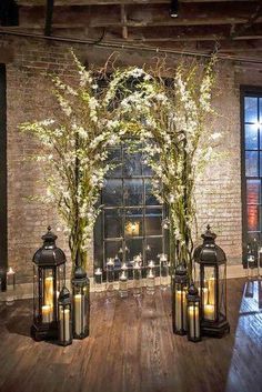 an outdoor ceremony with candles and flowers in vases on the side of the aisle