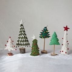 small christmas trees are lined up in the snow