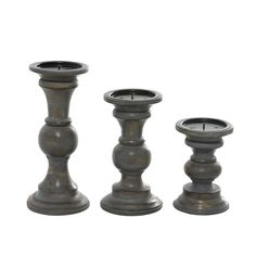 three metal candlesticks sitting next to each other