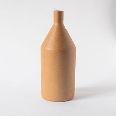 a brown vase sitting on top of a white table