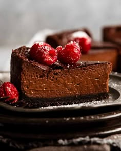 a piece of chocolate cheesecake with raspberries on top is sitting on a plate