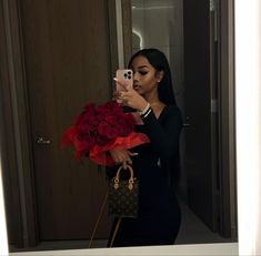 a woman taking a selfie while holding a bouquet of roses