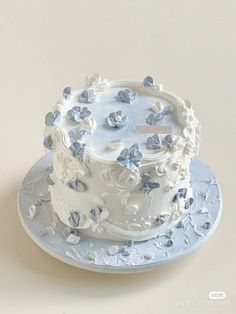 a white cake with blue butterflies on it