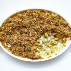 a white bowl filled with macaroni and cheese covered in parmesan sprinkles