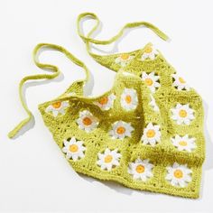 a crocheted bag with flowers on the front and side, sitting on a white surface