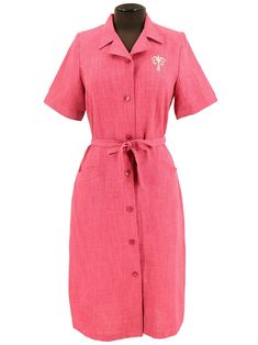 This 1940s-style button-through shift dress is realised in a bold pink colour, set off by fleur-de-lis embroidery at the breast and gold detail on the buttons. The dress buttons up the front, has two front pockets, and has a matching fabric belt.  simple yet stylish piece to compliment your vintage wardrobe. Not lined.  Sedagyl label. Pink Shirt Dress, Vintage Style Shoes, Colour Set, Vintage Knitwear, 1940s Style, Dress Buttons, Vintage Trousers, Vintage Suits, Vintage Wardrobe