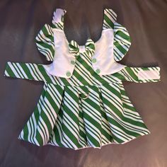 a green and white striped dress laying on top of a bed