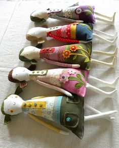 five colorful umbrellas are lined up in a row on a white cloth tablecloth