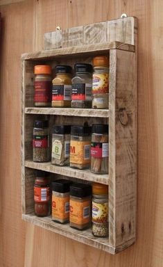 a wooden spice rack with jars and spices on it