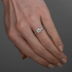 a woman's hand with a diamond ring on it