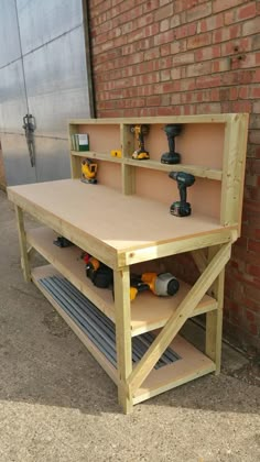 a workbench with tools on it in front of a brick wall