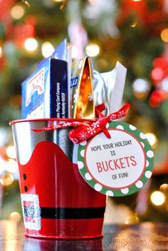 a bucket filled with holiday gifts on top of a table