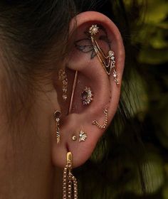 a woman wearing ear piercings and gold jewelry