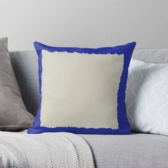 a blue and white pillow sitting on top of a couch