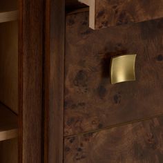 a close up of a wooden cabinet with a brass plate on the front and bottom