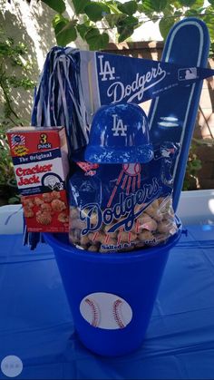 a blue bucket filled with snacks and baseball memorabilia