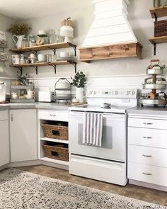 a white stove top oven sitting inside of a kitchen next to wooden shelves filled with pots and pans