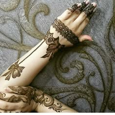 a woman's hand with henna tattoos on it