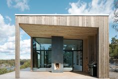 a wooden structure with glass doors on the outside and an open fire place in front