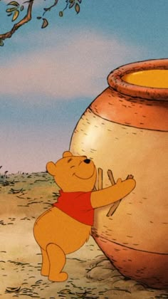 winnie the pooh standing next to a big pot