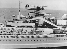 an old black and white photo of a ship with a plane on it's roof